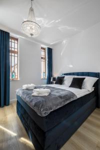1 dormitorio con 1 cama grande y cabecero azul en Apartament Royal Blue Ustka en Ustka