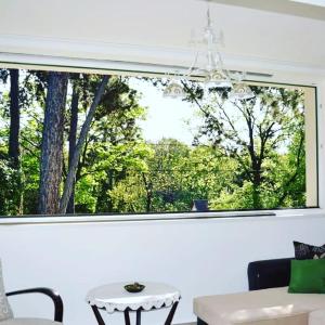 ventana en una sala de estar con mesa y lámpara de araña en Edit Villa en Matrafured