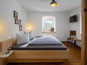 a bedroom with a large wooden bed with a window at Schneggnheisl Panoramaappartements in Sautens