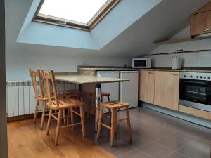 a kitchen with a table and chairs and a window at Ático La Plaza in Arriondas