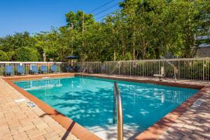 ein Pool in einem Garten mit einem Zaun in der Unterkunft Comfort Inn International Drive in Orlando