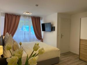a bedroom with a bed and a window with flowers at Prime Host Sophie Apartments in Karlsruhe