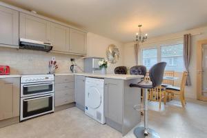 a kitchen with white appliances and a table and a chair at Town Square Townhouse - Best Location in Galway in Galway