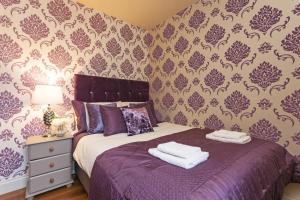 Un dormitorio con una cama morada con toallas. en Town Square Townhouse - Best Location in Galway, en Galway