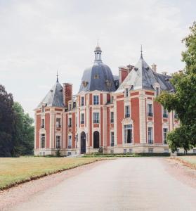 un gran edificio de ladrillo con una cúpula en la parte superior en Château du Domaine du Réveillon, en Entrains-sur-Nohain