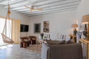 a living room with a couch and a ceiling fan at Luxury Villa Akes - Elegance Home in Isterni