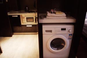 a kitchen with a washing machine and a microwave at Nanjing Kaibin Apartment -Xin Jie Kou in Nanjing