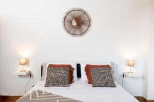 um quarto branco com uma cama com almofadas e um espelho em Borgo Hospitality em San Piero a Sieve