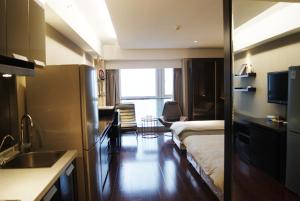 Habitación con cama y cocina con fregadero en Nanjing Kaibin Apartment -Xin Jie Kou, en Nanjing