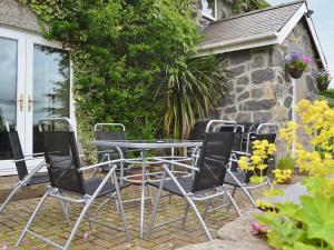 un grupo de sillas y una mesa en un patio en Carreg Y Garth Isaf - Hot Tub Nr Zip World en Bangor