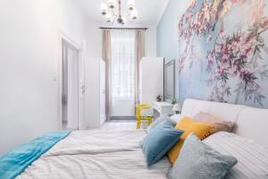 een slaapkamer met een wit bed en kleurrijke kussens bij Green apartment in Boedapest