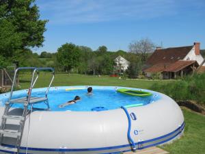 a couple of people in a large inflatable pool at Lalot gîte in Oulches