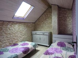 a bedroom with two beds and a window at Lalot gîte in Oulches