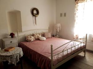 um quarto com uma cama com lençóis cor-de-rosa e uma janela em Szép Julis Vendégház em Cserépfalu