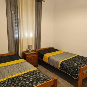 - une chambre avec 2 lits, une commode et une fenêtre dans l'établissement Caldas Relax & Leisure, à Caldas da Rainha