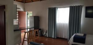 a room with a kitchen with a table and a window at Pomegranate Selfcatering apartment in Nelspruit