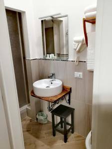 uma casa de banho com um lavatório e um espelho em Tre Orologi em Piombino