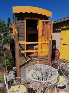 een terras met een tafel en stoelen bij la fée viviane et michel l'enchanteur in Robion en Luberon