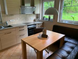 een keuken met een houten tafel en een eetkamer bij Ferienwohnung „Fiordaliso“ in Schweich