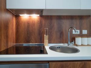 a kitchen with a sink and a wooden wall at Apartments Garden Azure Budva in Budva +96 photos