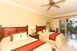 a bedroom with two beds and a ceiling fan at Cabo La Estancia in Cabo San Lucas