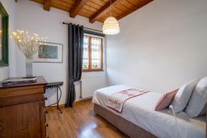 um quarto com uma cama, uma mesa e uma janela em La Cour St-Fulrad - Appartements em Saint-Hippolyte