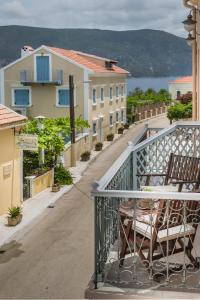 a balcony with a table and chairs on a street at Faros Suites (Adults Only) in Fiskardho