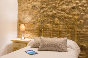 a bedroom with a bed with a stone wall at Carmen Vistas de la Alhambra in Granada +112 photos