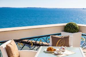 a table with a plate of food on a balcony with the ocean at Onyx Beach Residence - Free Parking & Beach Access in Sveti Vlas