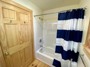 bagno con doccia con tenda blu e bianca di Pine Grove Cottages a Lincolnville Altre 111 foto