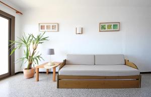 a white room with a bed and a table at Aparthotel Niu d´Aus in Portopetro