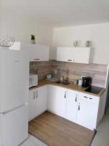 a white kitchen with white cabinets and a sink at plage du Môle in Cap d'Agde +9 photos