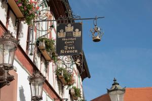 a sign for a restaurant on the side of a building at Hotel Zu den Drei Kronen in Seligenstadt