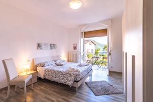 een slaapkamer met een bed, een stoel en een raam bij B&B e Residence Abbazia di Piona in Colico