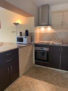 eine Küche mit Mikrowelle und Herd in der Unterkunft INDI Apartman Siófok in Siófok