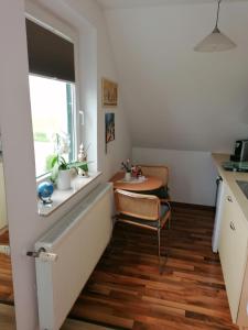 uma cozinha com uma mesa, uma cadeira e uma janela em Nahe bei Störti em Ralswiek