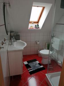 uma casa de banho com um WC, um lavatório e uma clarabóia em Nahe bei Störti em Ralswiek