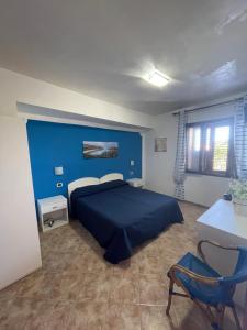 a bedroom with a blue bed and a blue wall at Il veliero blu camere sul porto in Lampedusa