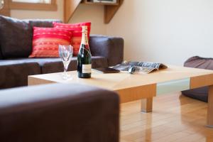 a bottle of champagne and a wine glass on a coffee table at Kamakura Apartments in Kutchan