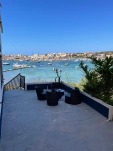 een patio met stoelen en uitzicht op een haven bij Il veliero blu camere sul porto in Lampedusa