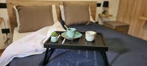 uma mesa com duas chávenas e um prato numa cama em La rosa dei venti-Portovenere em Portovenere