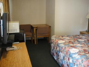 a hotel room with a bed and a desk with a television at California Motel in California