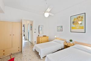 1 Schlafzimmer mit 2 Betten und einem Deckenventilator in der Unterkunft Aci Castello Seaview Apartment with Parking in Aci Castello