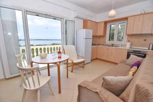 a kitchen and living room with a table and a couch at Villa Menethea Sea View - 5min from Issos beach in Línia