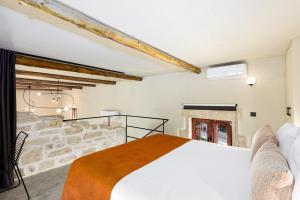 a bedroom with a bed and a stone wall at Villa Rossa in Arkhondikí +43 photos