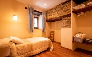 Un dormitorio con una cama y una pared de piedra. en Vieiro Verde, en Vieiro