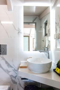 a white bathroom with a sink and a mirror at Lilian Loft Sea View - Adults Only in Plakias