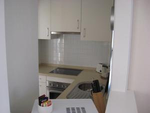 a small kitchen with white cabinets and a sink at First Floor Non Smoking Air Conditioned 4 Person Luxury Golf Apartment in Corvera