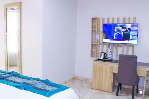 a bedroom with a bed and a desk with a television at Hilton Leisure Resort in Akwa