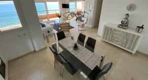a dining room and living room with a table and chairs at Los Reales 8B in Estepona